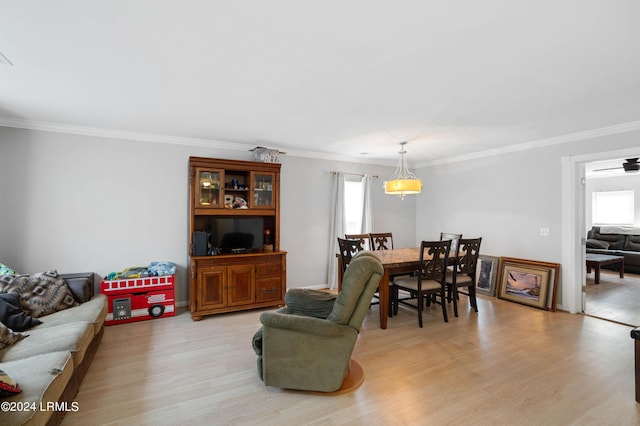 living room with crown molding and light wood-type flooring