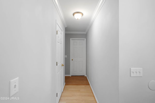 hallway featuring ornamental molding and light hardwood / wood-style floors