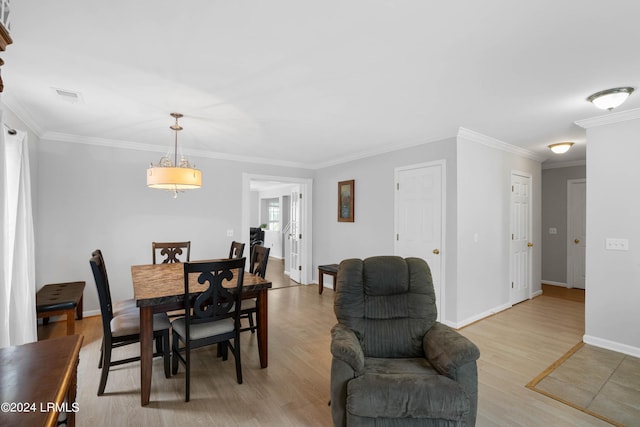 dining area featuring crown molding and light hardwood / wood-style flooring