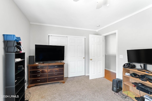 bedroom featuring crown molding, ceiling fan, light colored carpet, and a closet