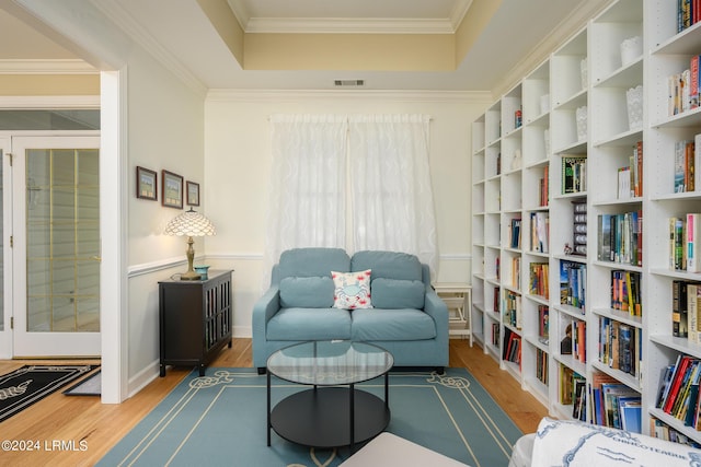 sitting room featuring wood-type flooring and a raised ceiling