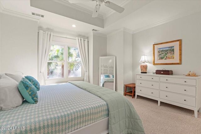 bedroom featuring crown molding, ceiling fan, a tray ceiling, and light colored carpet