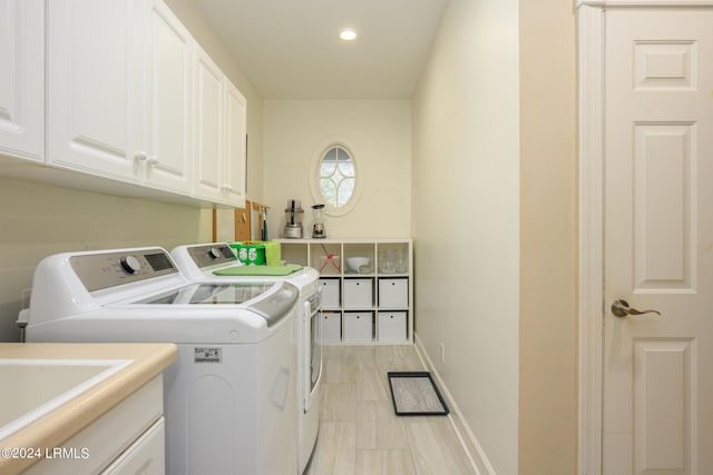 clothes washing area featuring cabinets and washing machine and dryer