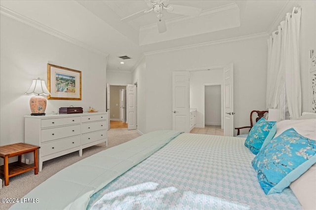 bedroom with a tray ceiling, crown molding, light colored carpet, and ceiling fan