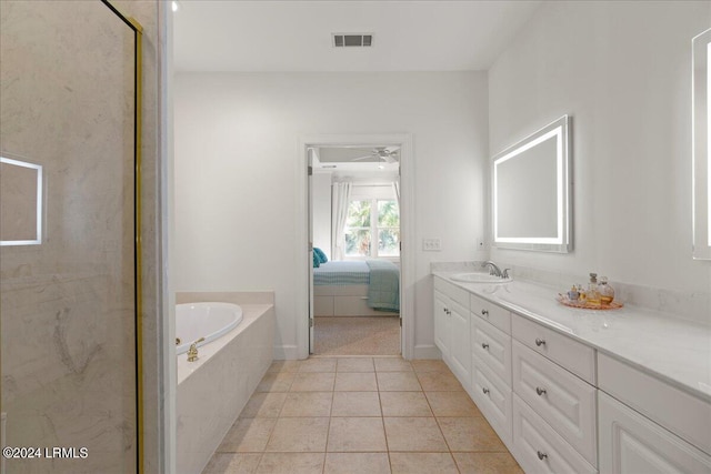 bathroom with vanity, a relaxing tiled tub, and tile patterned floors