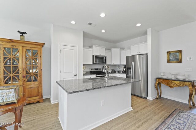 257 Garden Gate Cir E, Hardeeville, SC 29927 - kitchen featuring appliances with stainless steel finishes, light wood-type flooring, dark stone counters, white cabinetry, and recessed lighting