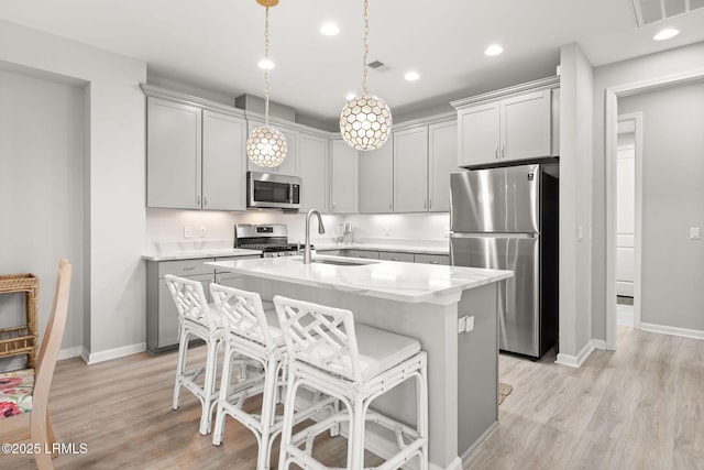 kitchen featuring baseboards, visible vents, appliances with stainless steel finishes, and a sink
