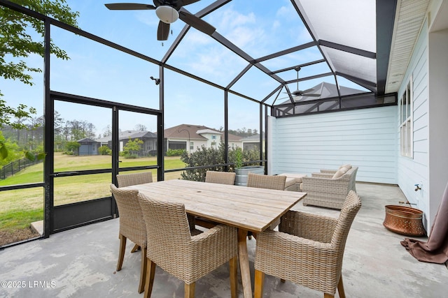 sunroom featuring ceiling fan and a residential view