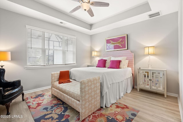 bedroom featuring baseboards, visible vents, wood finished floors, and a ceiling fan