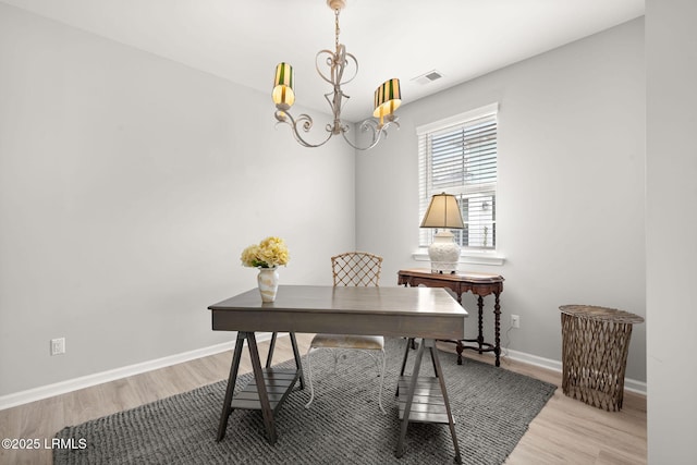office space featuring a notable chandelier, visible vents, wood finished floors, and baseboards