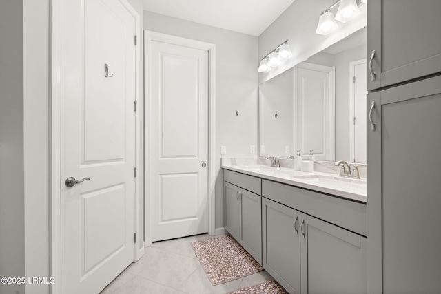 bathroom with tile patterned flooring, a sink, and double vanity