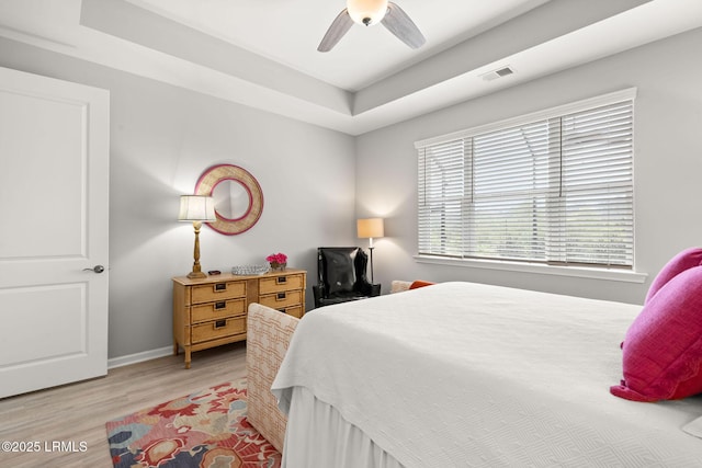 bedroom with ceiling fan, light wood-type flooring, visible vents, and baseboards
