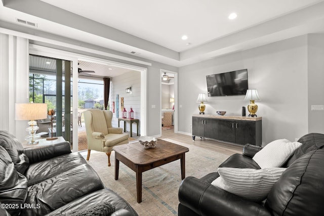 living room with light wood-style flooring, visible vents, ceiling fan, baseboards, and recessed lighting