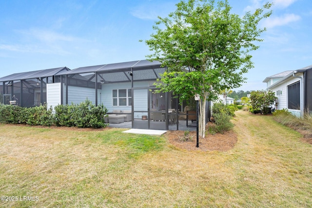 rear view of house featuring a lanai and a yard