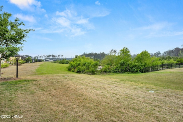view of community featuring fence and a yard