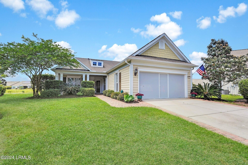 view of front of house with a garage and a front lawn