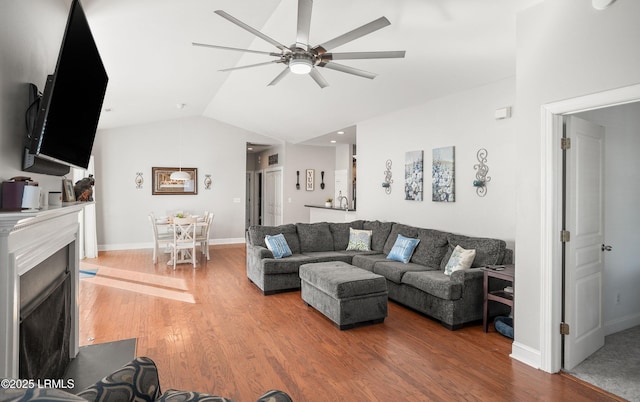 living room with lofted ceiling, wood-type flooring, and ceiling fan