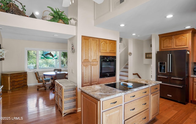 3 Ocean Marsh Ln, Harbor Island, SC 29920 - kitchen with black appliances, light wood-style floors, light stone countertops, a kitchen island, and recessed lighting