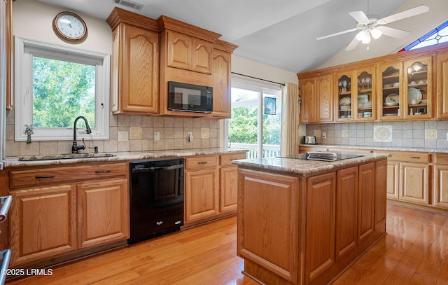 3 Ocean Marsh Ln, Harbor Island, SC 29920 - kitchen featuring black appliances, light wood-style flooring, vaulted ceiling, backsplash, and light stone countertops