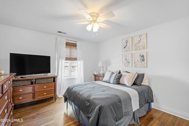 bedroom with wood-type flooring, crown molding, and ceiling fan