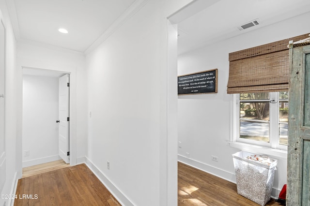 hall with hardwood / wood-style flooring and crown molding