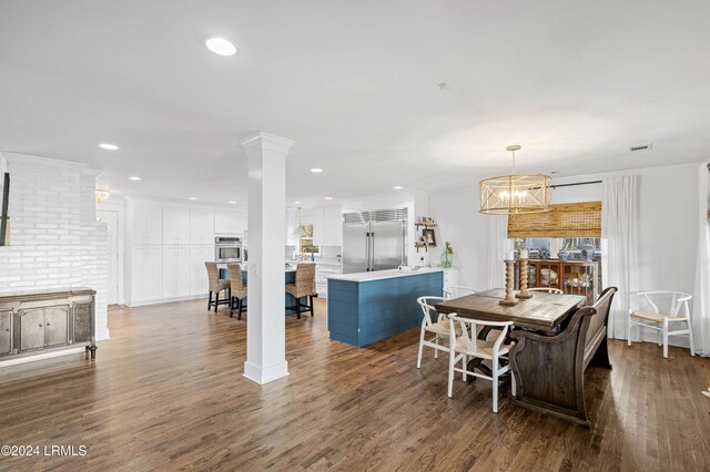 dining area with hardwood / wood-style flooring and decorative columns