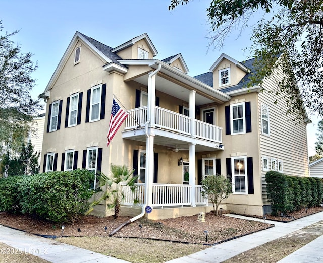 view of front of property featuring a porch, a balcony, and stucco siding