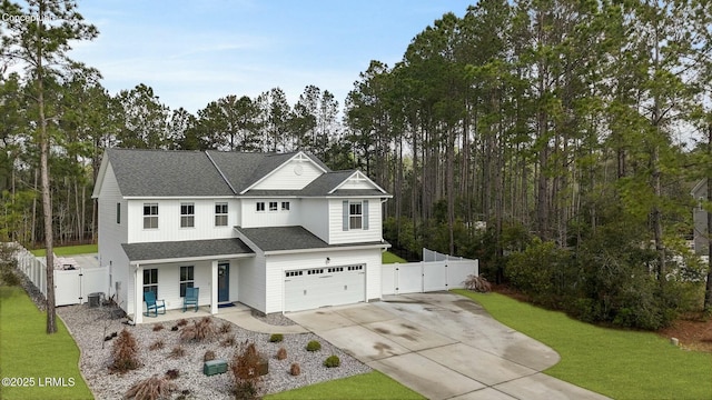 view of front of property with a shingled roof, driveway, a gate, and a front lawn