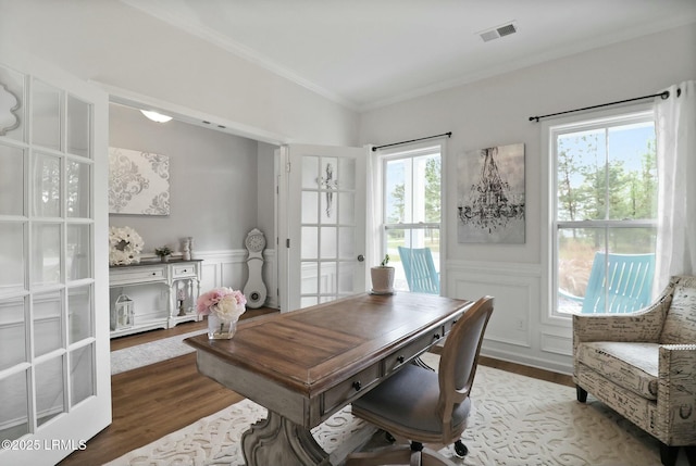 home office with wainscoting, wood finished floors, and visible vents