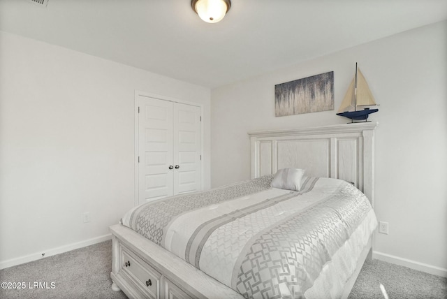 bedroom featuring light colored carpet, a closet, and baseboards