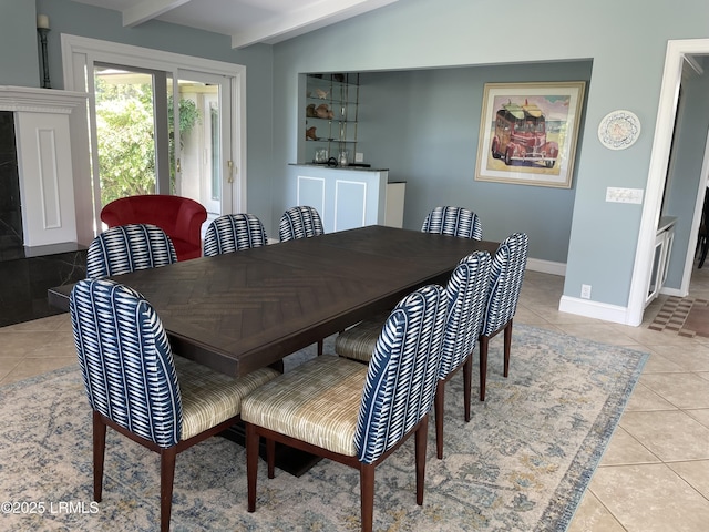 dining area with light tile patterned floors and beamed ceiling