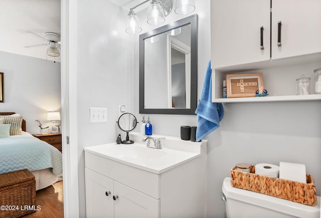 bathroom featuring vanity, ceiling fan, wood-type flooring, and toilet