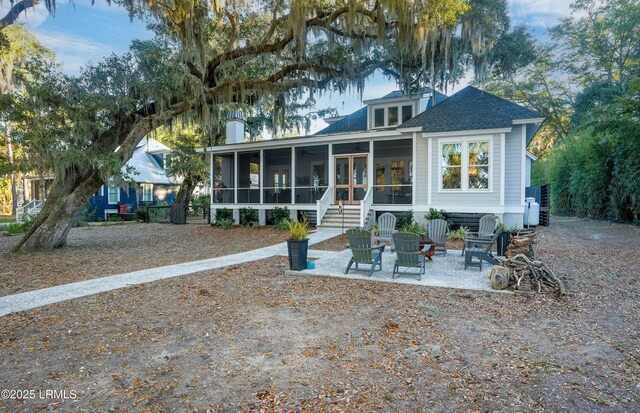 rear view of house featuring an outdoor fire pit, a patio, and a sunroom