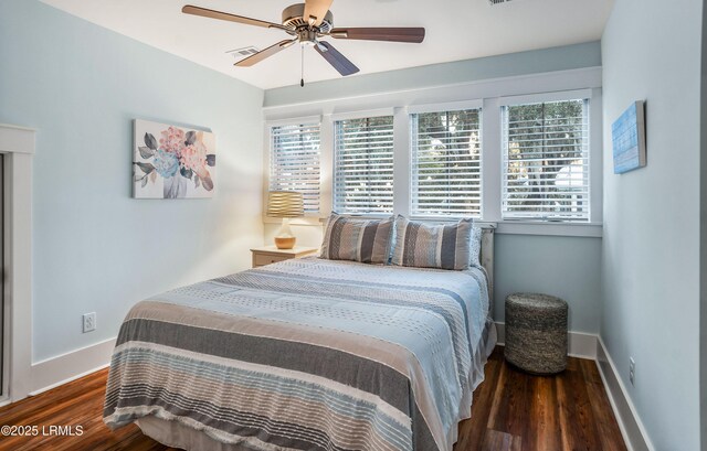 bedroom featuring multiple windows, dark wood-type flooring, and ceiling fan