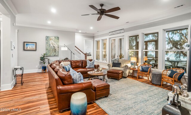 living room featuring ceiling fan, ornamental molding, and light hardwood / wood-style flooring