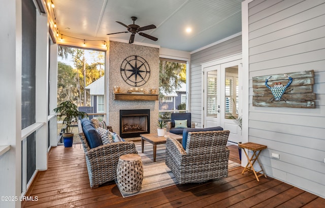 sunroom / solarium featuring a large fireplace, plenty of natural light, french doors, and ceiling fan