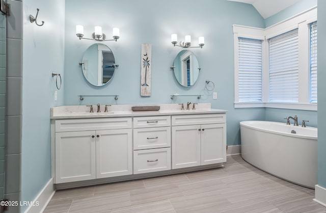 bathroom featuring lofted ceiling, vanity, and a bathing tub