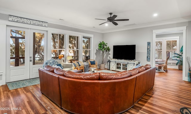 living room with hardwood / wood-style floors, ornamental molding, and ceiling fan