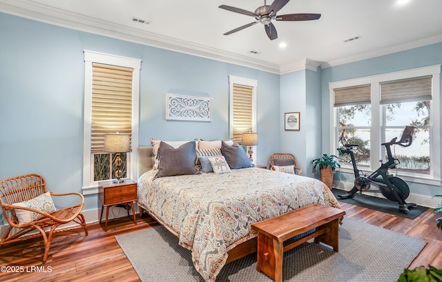 bedroom featuring hardwood / wood-style flooring, crown molding, and ceiling fan