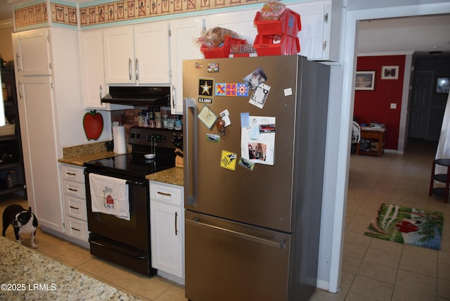 kitchen with light tile patterned floors, stainless steel fridge, white cabinetry, light stone counters, and black range with electric cooktop