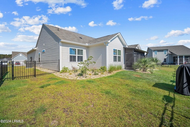 exterior space featuring a lawn, fence, and a sunroom