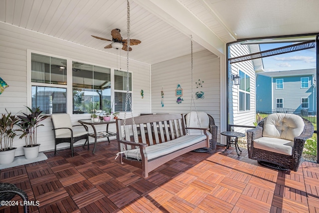 sunroom featuring lofted ceiling with beams and a ceiling fan