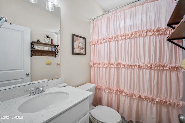 bathroom featuring vanity, a shower with shower curtain, and toilet