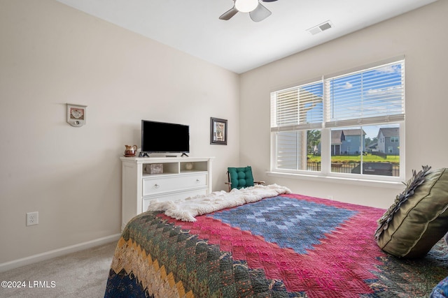 carpeted bedroom featuring baseboards, visible vents, and ceiling fan