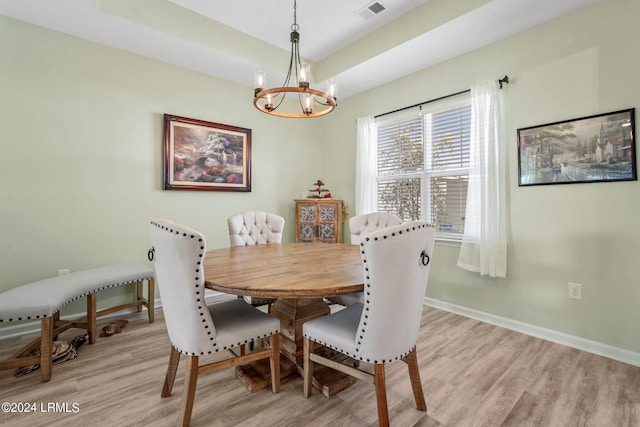 dining area featuring visible vents, a notable chandelier, light wood-style flooring, and baseboards