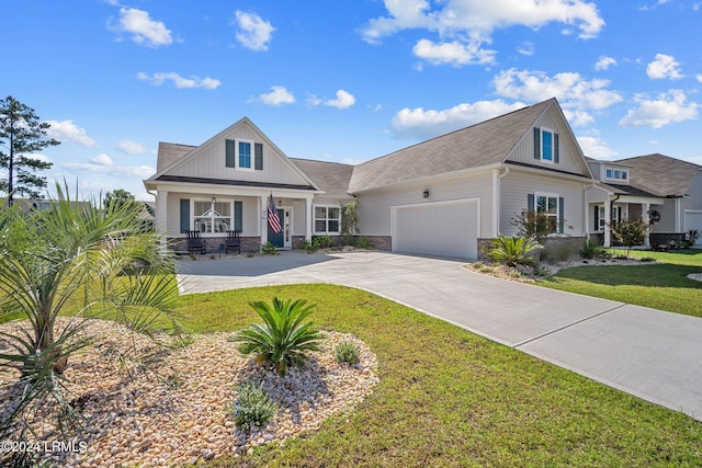 view of front of house featuring a porch, concrete driveway, a front yard, a garage, and stone siding