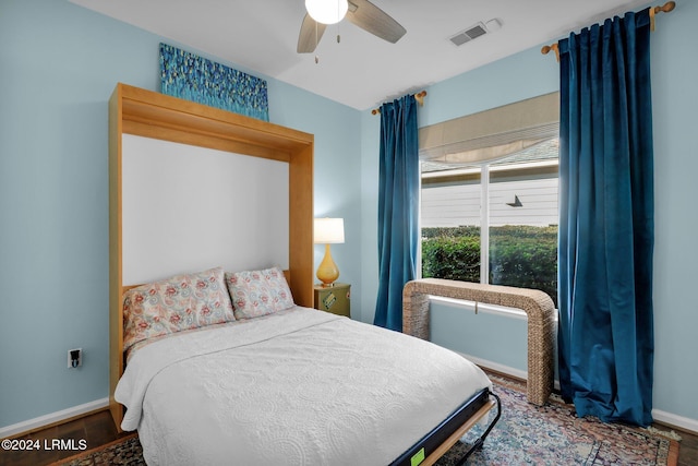 bedroom with dark hardwood / wood-style flooring and ceiling fan