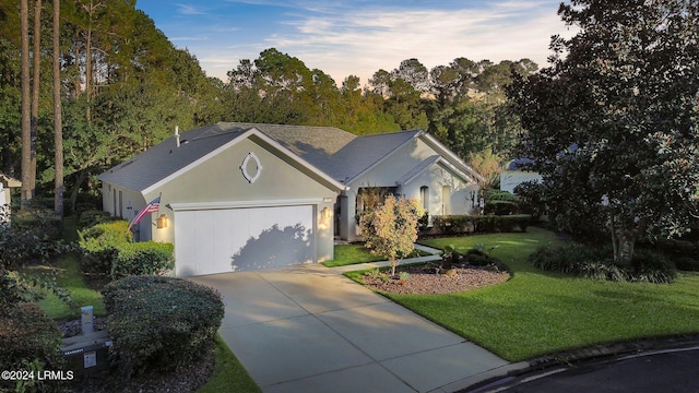 single story home with a garage and a front lawn