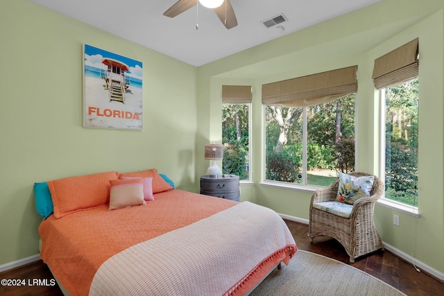 bedroom featuring multiple windows, dark hardwood / wood-style flooring, and ceiling fan