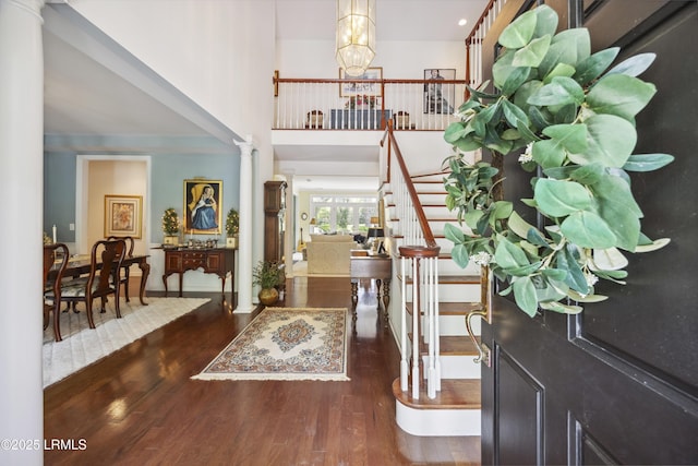 2 Lenox Ln, Hilton Head Island, SC 29926 - entryway with wood finished floors, a chandelier, decorative columns, a high ceiling, and stairs